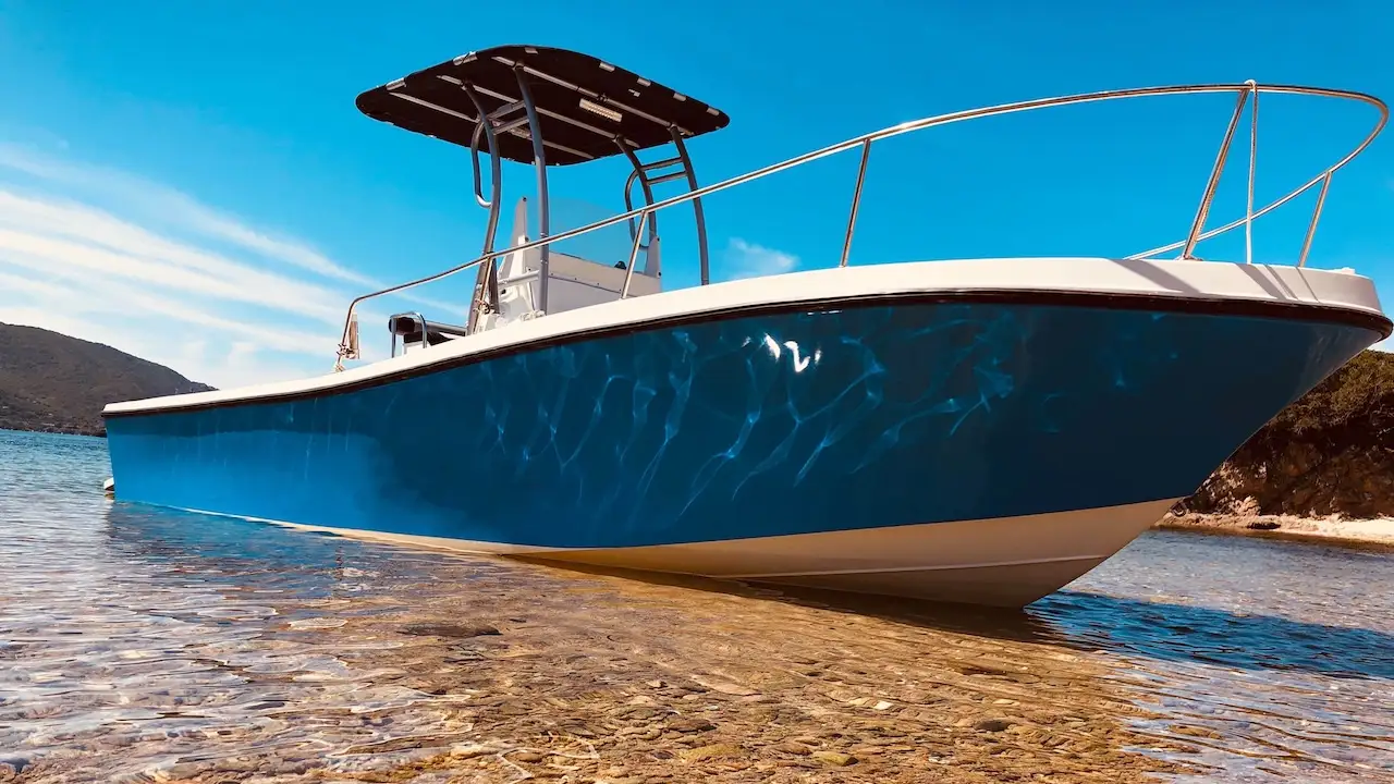 Bateau bleu de Santa Manza Croisière posé sur la plage avec vue de côté en location privée