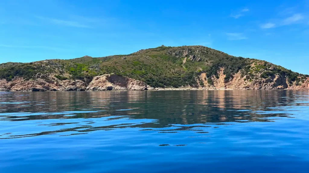 Surface marine parfaitement calme et réfléchissante dans la baie de Santa Manza, conditions idéales